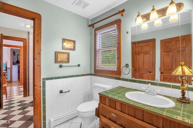771 Cedar Grove Church Rd, Roxboro, NC 27574 - bathroom featuring a baseboard radiator, toilet, vanity, tile walls, and a wainscoted wall