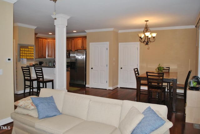 living area featuring dark wood-style floors, a chandelier, baseboards, ornate columns, and recessed lighting