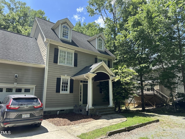 view of front facade featuring a shingled roof and driveway