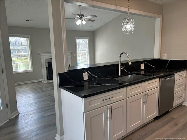 kitchen with a sink, dark countertops, plenty of natural light, and beamed ceiling