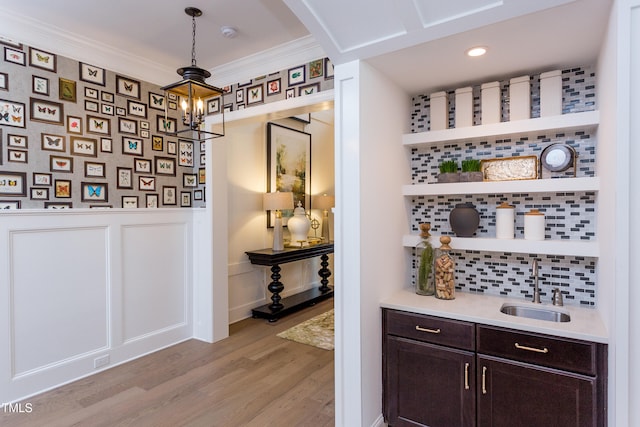 1412 Auman Rd, Raleigh, NC 27603 - indoor wet bar featuring light wood-type flooring, arched walkways, decorative backsplash, wainscoting, and hanging light fixtures