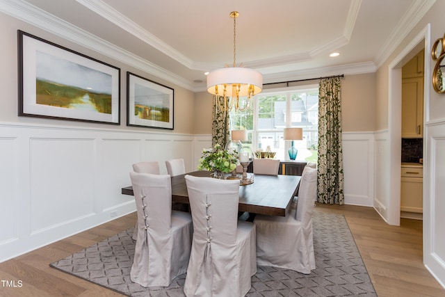 1412 Auman Rd, Raleigh, NC 27603 - dining area featuring a decorative wall, a chandelier, wood finished floors, crown molding, and a raised ceiling