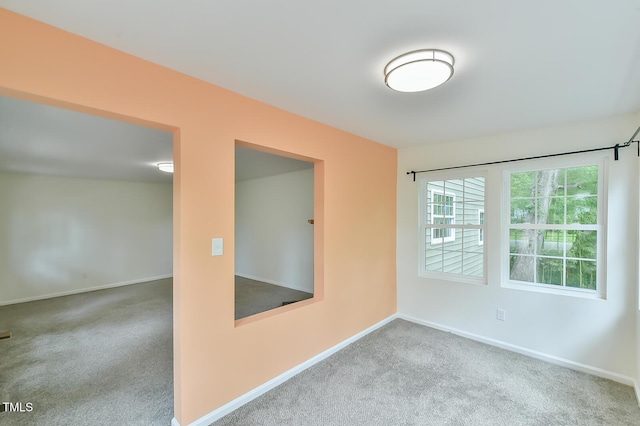 unfurnished room with carpet flooring and baseboards
