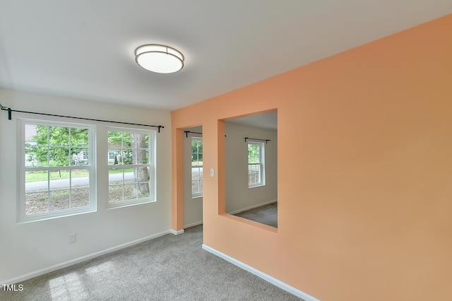 spare room featuring baseboards and carpet floors