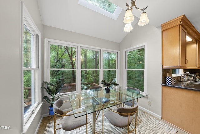 dining area with a skylight, lofted ceiling, and baseboards