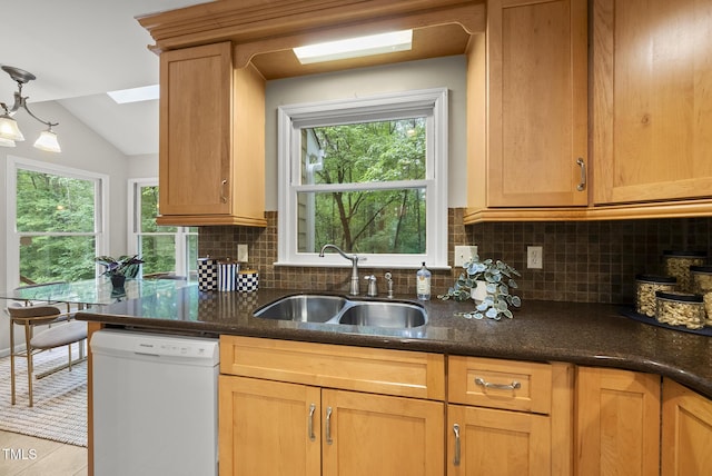 kitchen featuring white dishwasher, a sink, tasteful backsplash, dark stone counters, and lofted ceiling