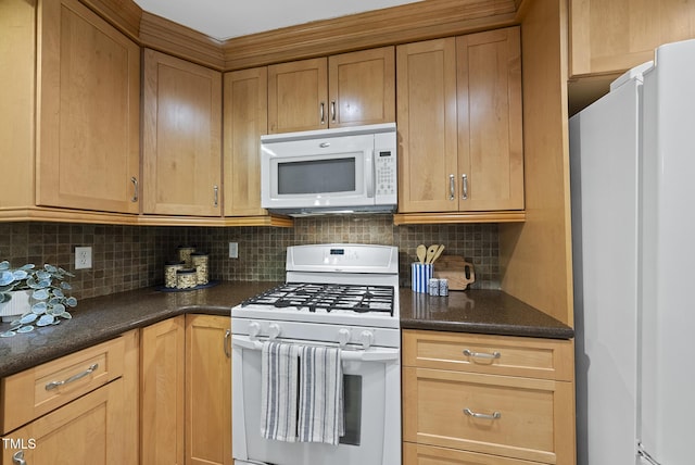 kitchen with white appliances, decorative backsplash, and dark stone counters