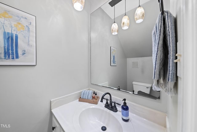 bathroom featuring lofted ceiling, vanity, and toilet