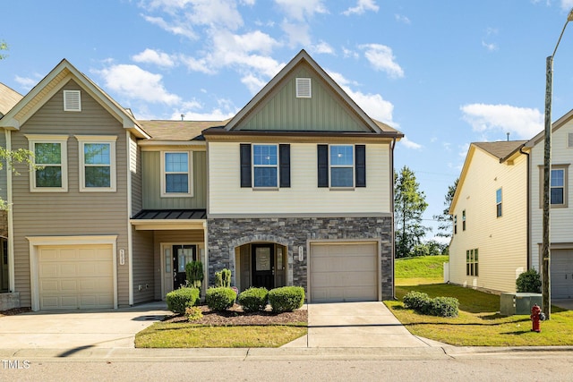 view of front of property featuring board and batten siding, stone siding, driveway, and an attached garage