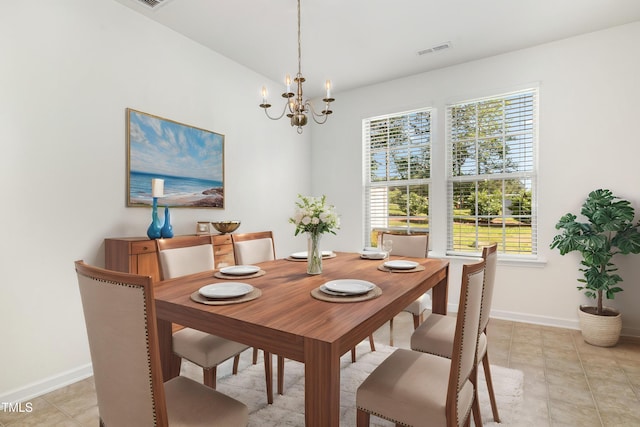 dining space featuring baseboards and a chandelier