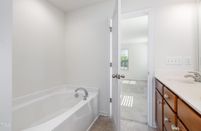 bathroom featuring double vanity, a bath, baseboards, and tile patterned floors