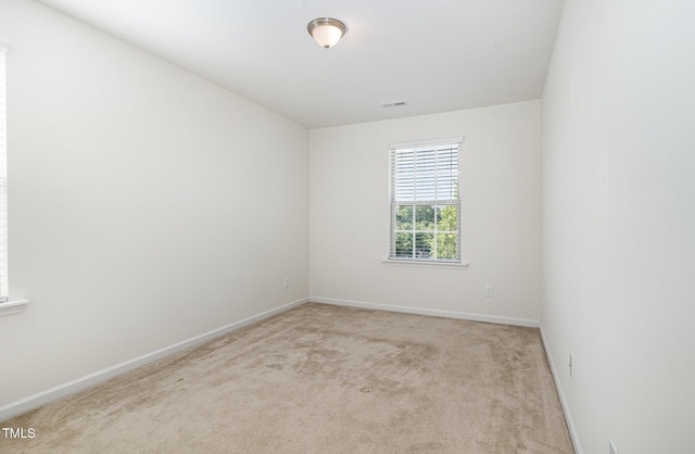 carpeted empty room featuring baseboards