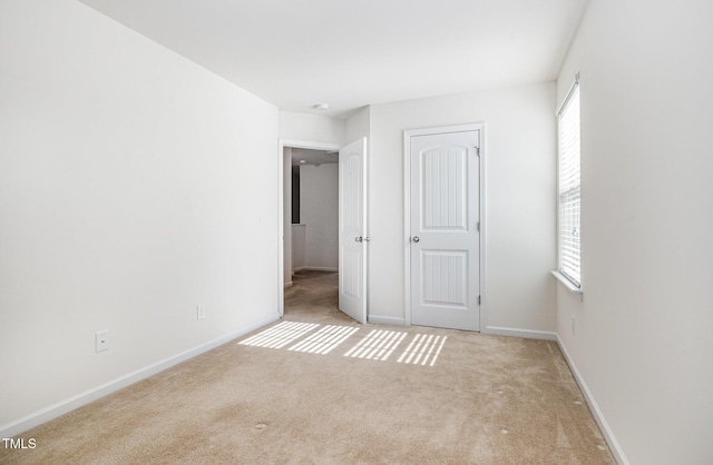 unfurnished bedroom featuring carpet flooring and baseboards