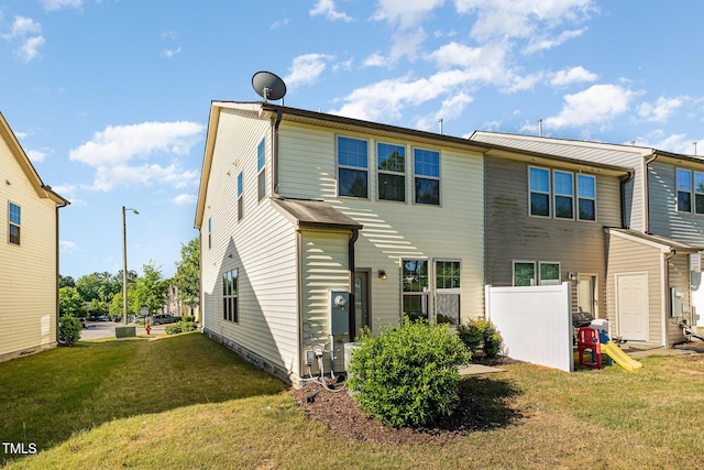 rear view of house featuring a yard