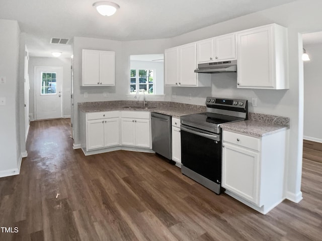 kitchen featuring appliances with stainless steel finishes, under cabinet range hood, a sink, white cabinets, and dark wood-style flooring