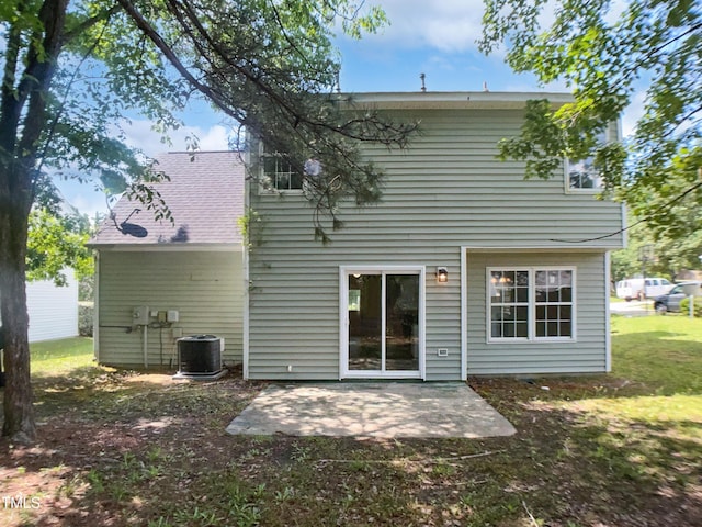 rear view of property featuring central air condition unit, a patio area, and a yard