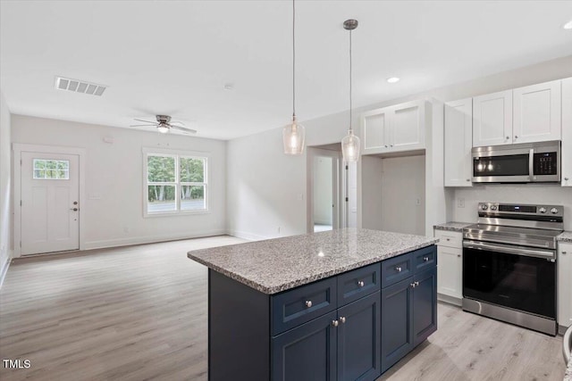 kitchen with stainless steel appliances, light wood-style flooring, white cabinets, a ceiling fan, and a kitchen island