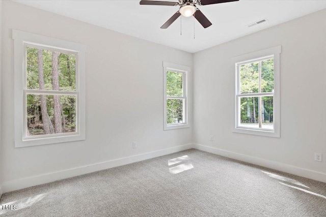 carpeted empty room featuring plenty of natural light and baseboards