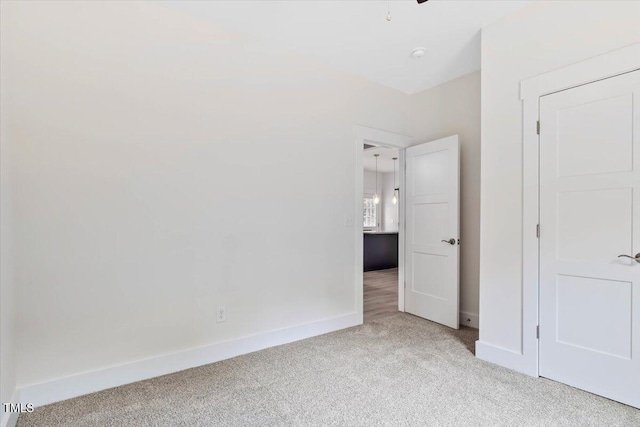 unfurnished bedroom with light carpet and baseboards