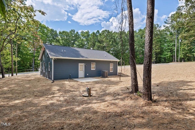 back of property featuring central air condition unit and a shingled roof