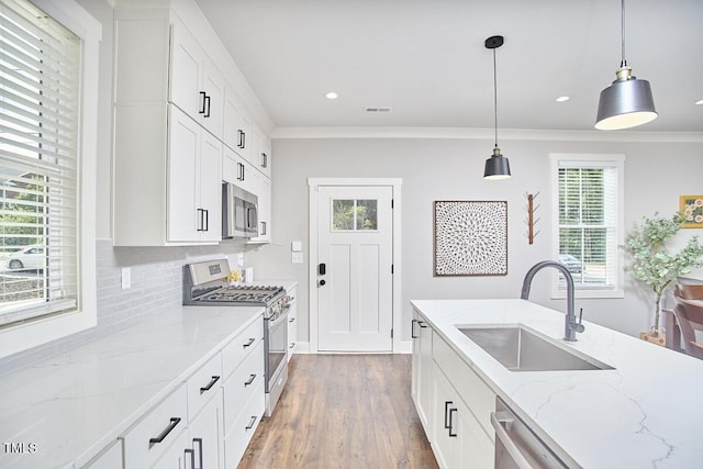 941 W Club Blvd, Durham, NC 27701 - kitchen with stainless steel appliances, a sink, tasteful backsplash, ornamental molding, and wood finished floors
