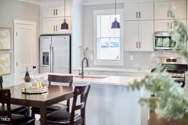 941 W Club Blvd, Durham, NC 27701 - kitchen featuring stainless steel appliances, a sink, light countertops, tasteful backsplash, and decorative light fixtures