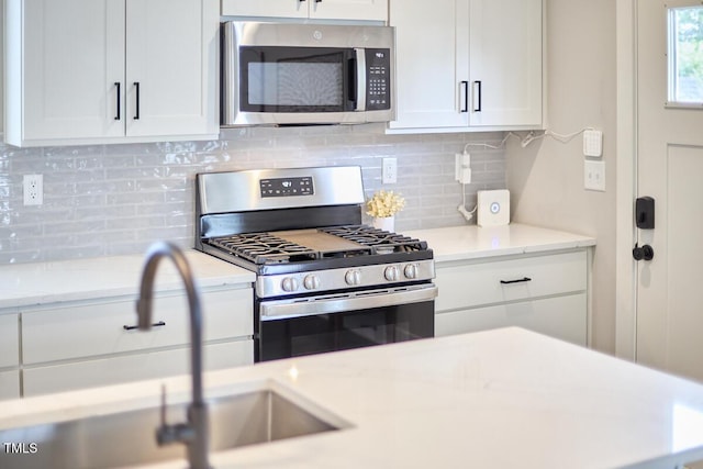 941 W Club Blvd, Durham, NC 27701 - kitchen featuring stainless steel appliances, white cabinets, a sink, and backsplash