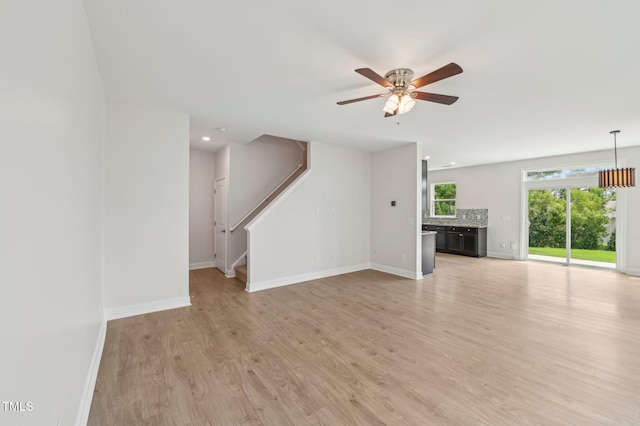 1534 Glenwater Dr, Cary, NC 27519 - unfurnished living room featuring ceiling fan, baseboards, light wood-style flooring, stairs, and recessed lighting