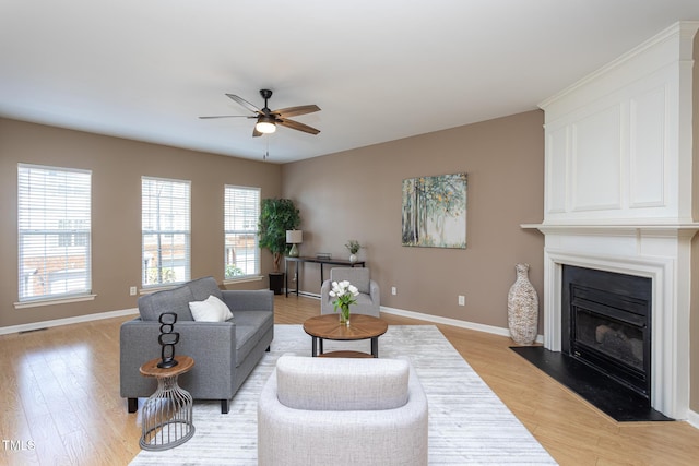 7244 Galon Glen Rd, Raleigh, NC 27613 - living room featuring a ceiling fan, light wood-style floors, baseboards, and a fireplace