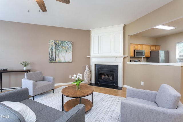 7244 Galon Glen Rd, Raleigh, NC 27613 - living room featuring baseboards, a ceiling fan, light wood finished floors, and a fireplace