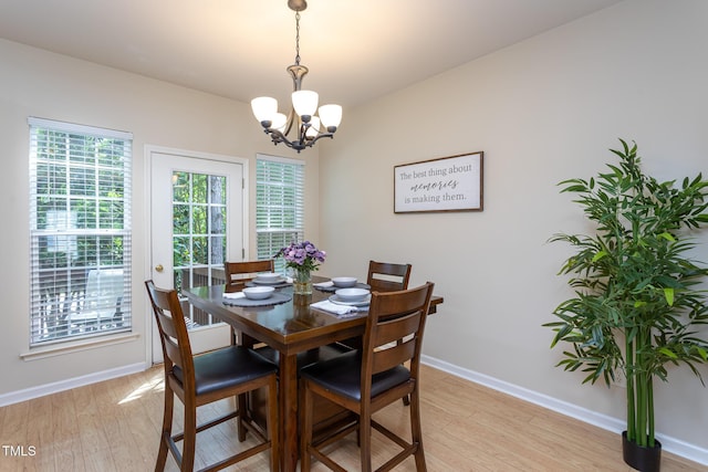 7244 Galon Glen Rd, Raleigh, NC 27613 - dining room featuring a chandelier, light wood-style floors, and baseboards