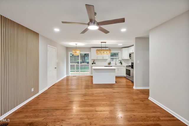2200 Wyman Pl, Durham, NC 27707 - kitchen featuring ceiling fan, stainless steel appliances, light countertops, light wood-style floors, and white cabinetry