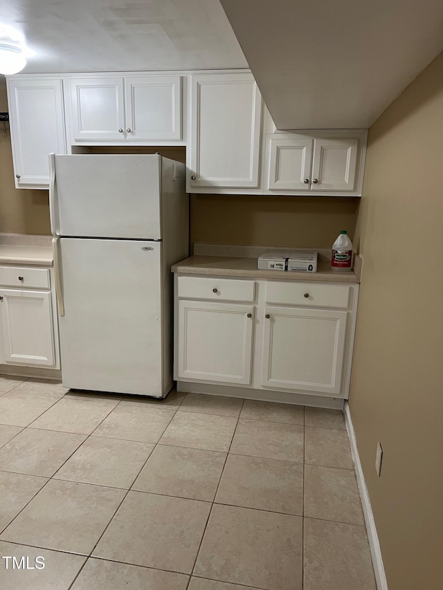 5932 Johnson Pond Rd, Fuquay Varina, NC 27526 - kitchen with freestanding refrigerator, light tile patterned floors, white cabinetry, and light countertops
