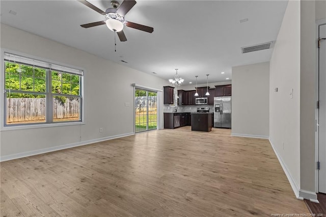 4572 Headwind Dr, Fayetteville, NC 28306 - unfurnished living room featuring a ceiling fan, a chandelier, baseboards, light wood finished floors, and recessed lighting