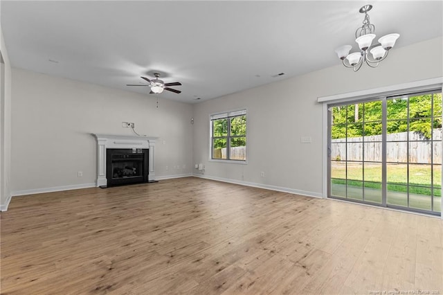 4572 Headwind Dr, Fayetteville, NC 28306 - unfurnished living room featuring a ceiling fan, wood finished floors, a chandelier, baseboards, and a fireplace