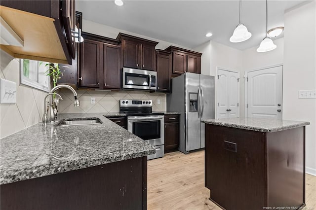 4572 Headwind Dr, Fayetteville, NC 28306 - kitchen featuring stainless steel appliances, a sink, dark stone counters, dark brown cabinetry, and recessed lighting