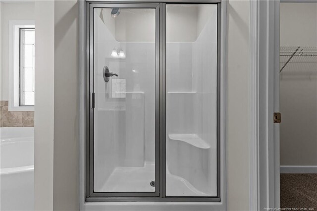 4572 Headwind Dr, Fayetteville, NC 28306 - bathroom featuring a shower stall, a garden tub, and a spacious closet