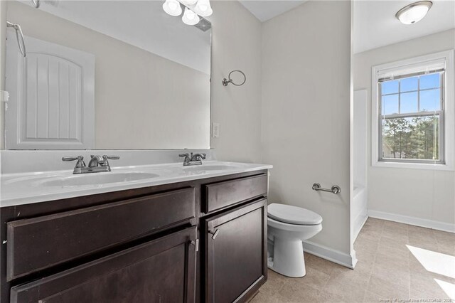 4572 Headwind Dr, Fayetteville, NC 28306 - bathroom with toilet, baseboards, double vanity, and tile patterned floors