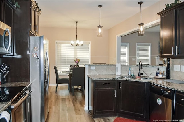 196 Wedgefield Dr, Raeford, NC 28376 - kitchen with stainless steel appliances, light wood-style flooring, a chandelier, a sink, and a peninsula