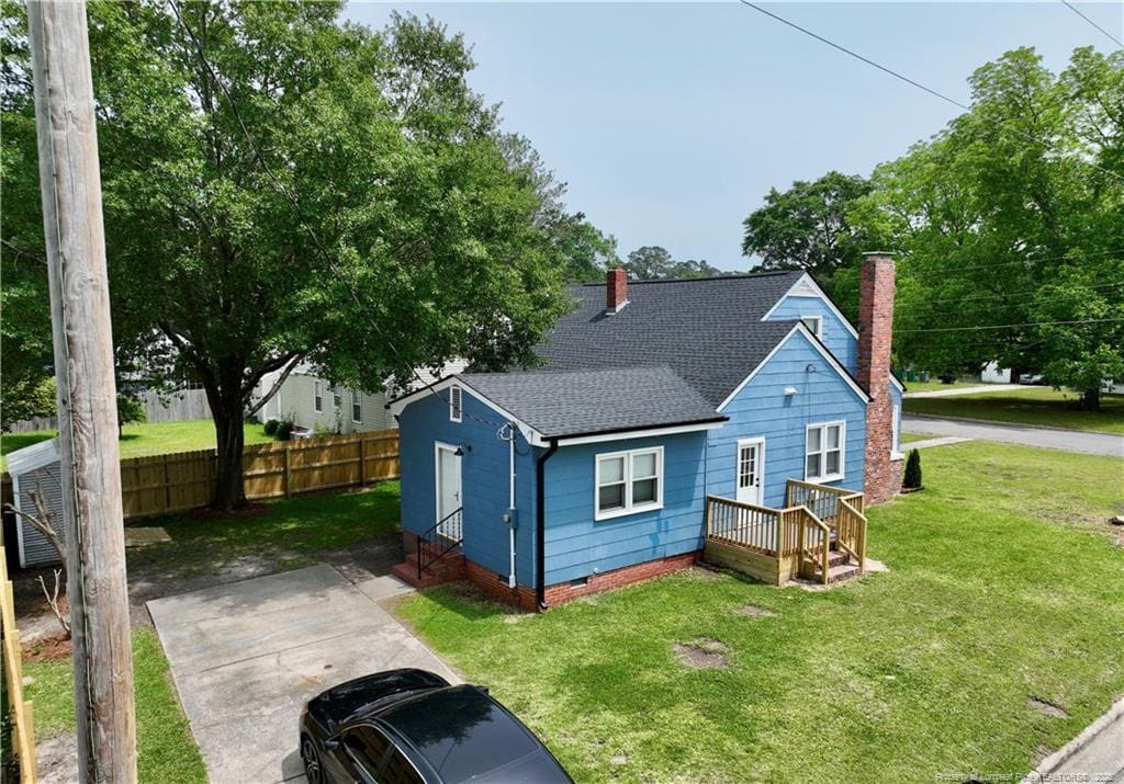 back of property featuring roof with shingles, crawl space, and a chimney