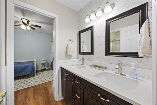 full bath with ensuite bathroom, ceiling fan, wood finished floors, and double vanity