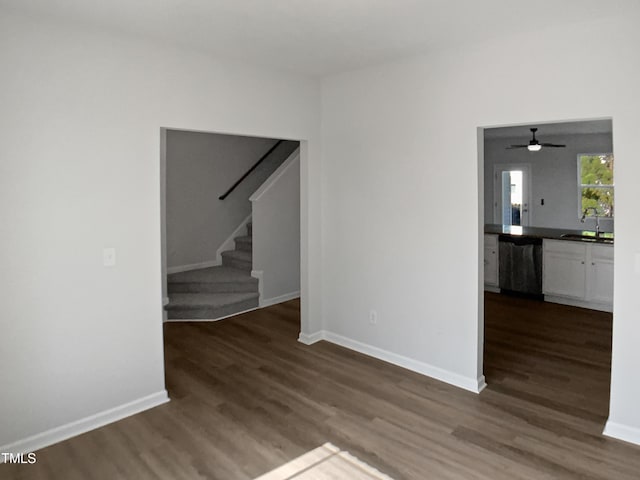 8891 Commons Townes Dr, Raleigh, NC 27616 - unfurnished living room featuring a sink, wood finished floors, stairway, and a ceiling fan