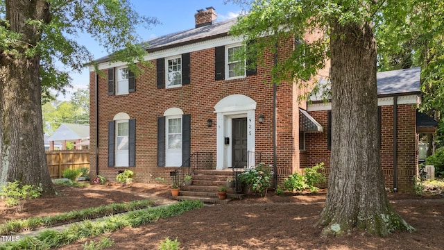 925 S Chestnut St, Henderson, NC 27536 - view of front facade featuring brick siding, a chimney, and fence