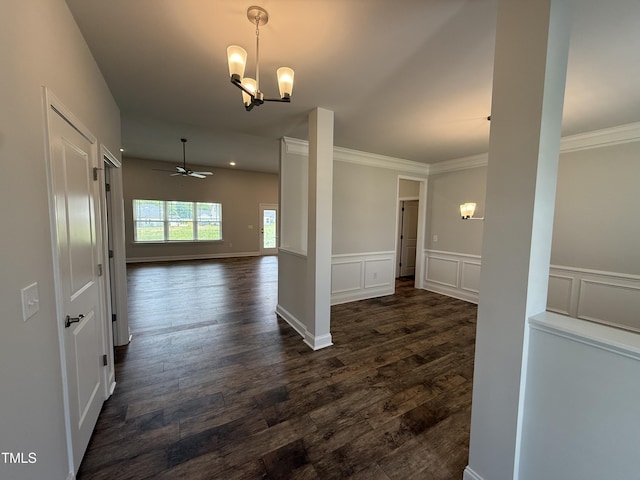 corridor with a chandelier, dark wood-style flooring, ornamental molding, and wainscoting