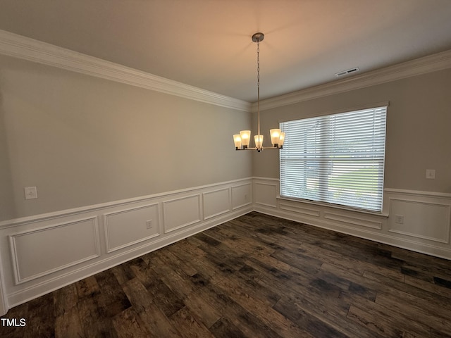 empty room featuring a chandelier, ornamental molding, wainscoting, dark wood-style floors, and a decorative wall