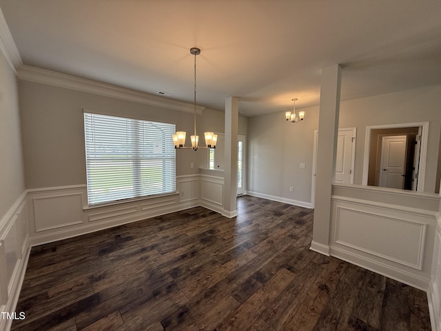 unfurnished dining area with a chandelier, dark wood finished floors, a wainscoted wall, a decorative wall, and crown molding
