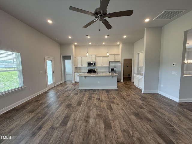 kitchen featuring stainless steel appliances, a center island with sink, a ceiling fan, a sink, and white cabinets