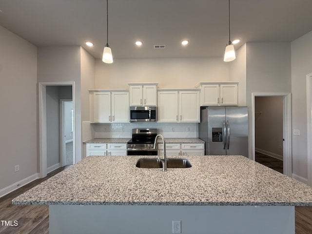 kitchen featuring stainless steel appliances, a sink, white cabinetry, baseboards, and recessed lighting