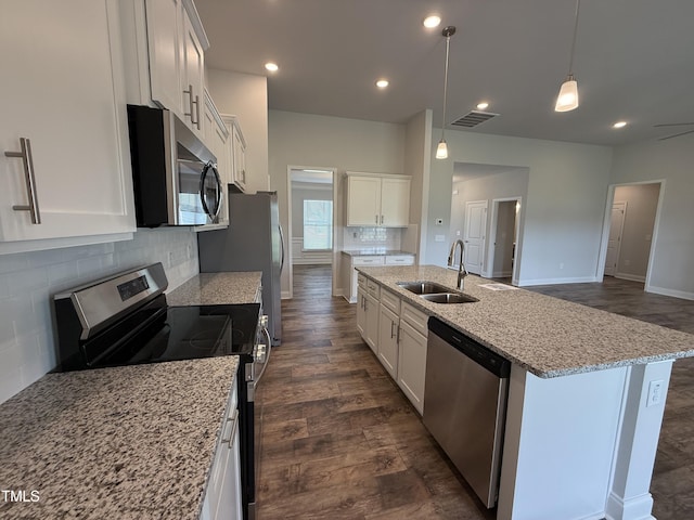 kitchen with stainless steel appliances, a sink, white cabinetry, a kitchen island with sink, and recessed lighting