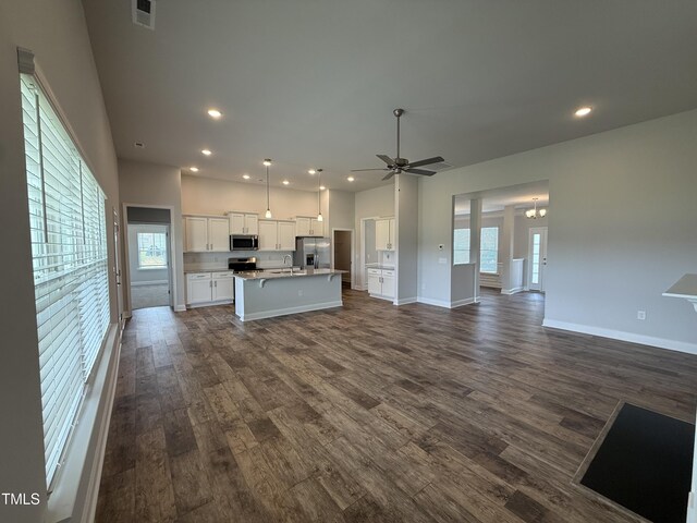 living area with recessed lighting, dark wood finished floors, a ceiling fan, and baseboards